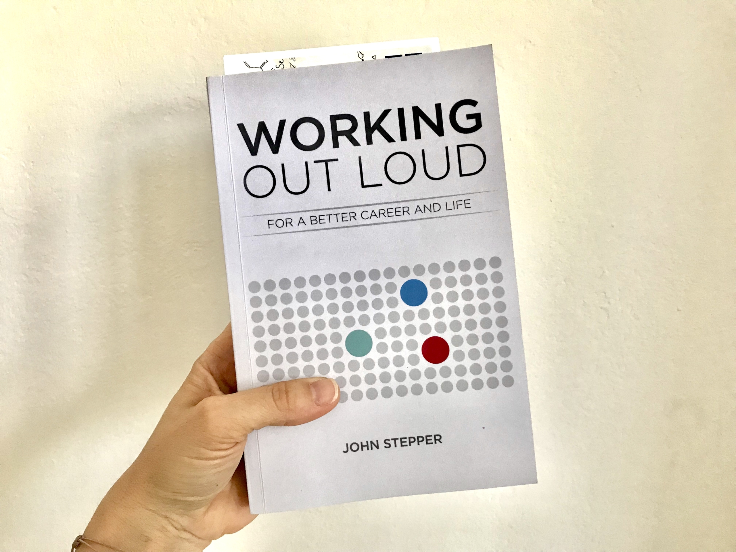 Buch "Working Out Loud" von John Stepper in der Hand gehalten, aus "10 Beiträge, die mir geholfen haben, Working Out Loud zu verstehen und anzuwenden"